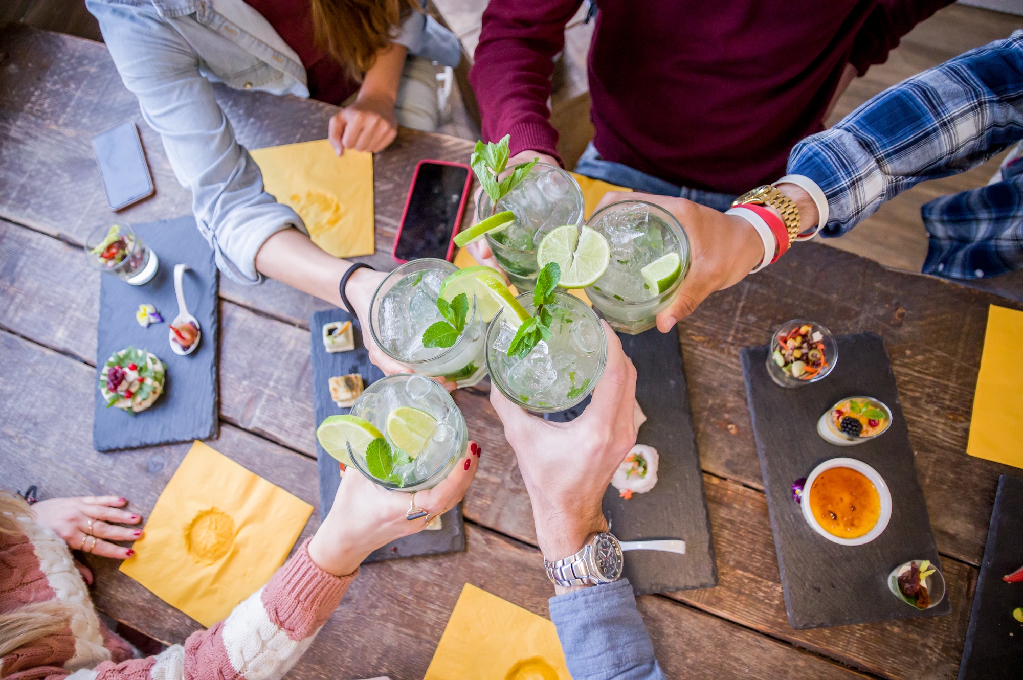 Happy friends drinking mojito at bar restaurant.